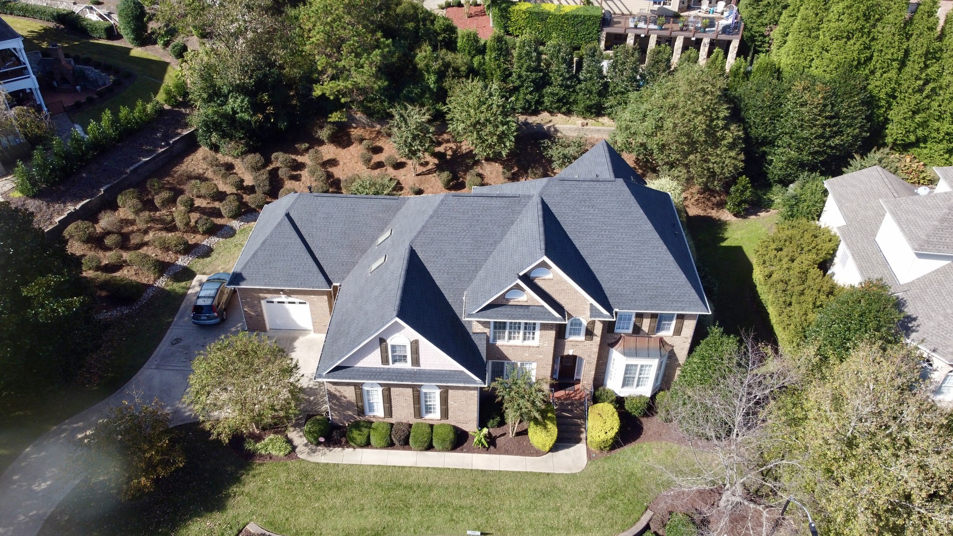 Aerial view of a roof on a landscaped residential property published in Sunset Roofing and Construction's project gallery