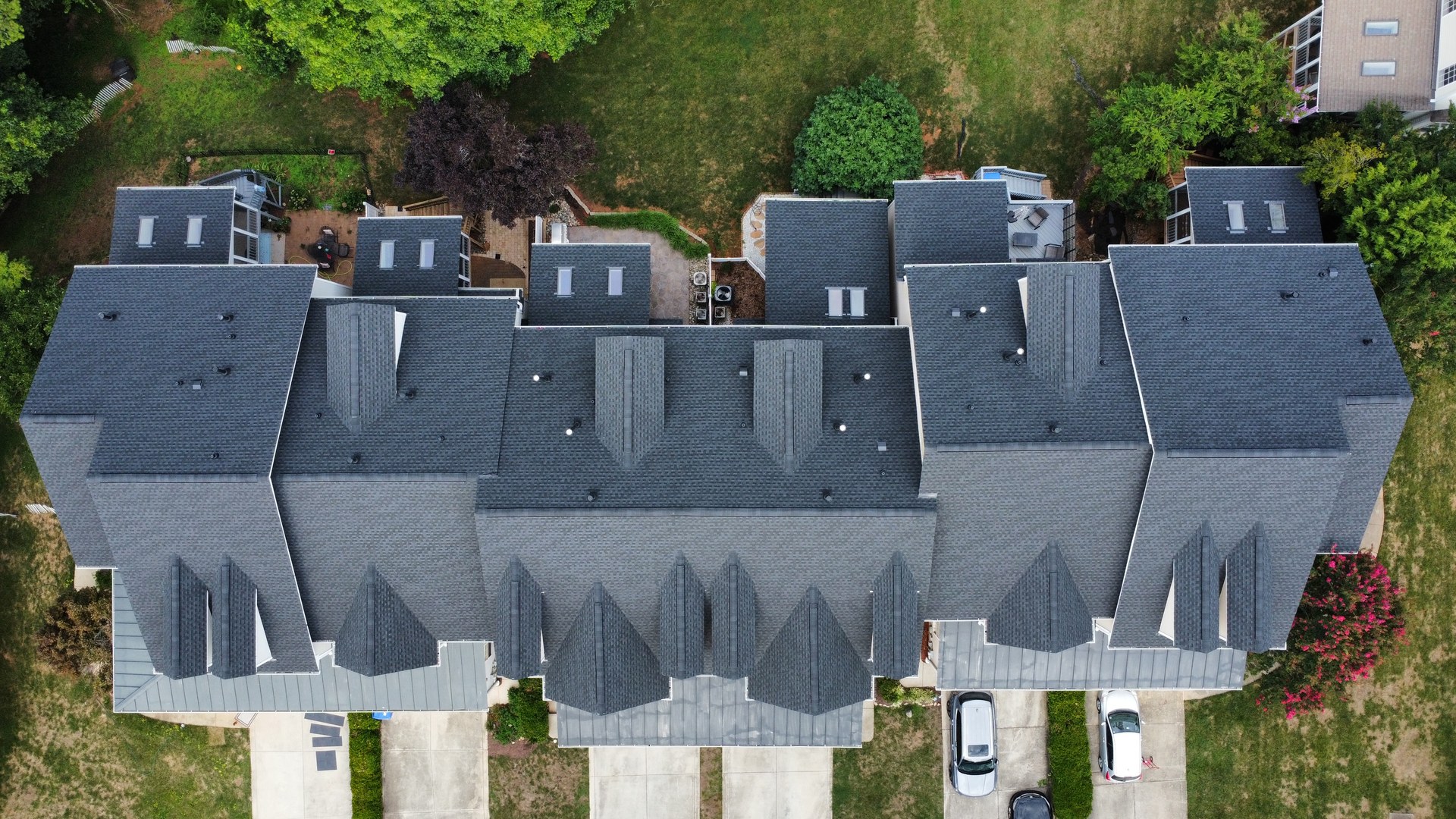 Top-down aerial view of a multi-unit building roof published in Sunset Roofing and Construction's project gallery