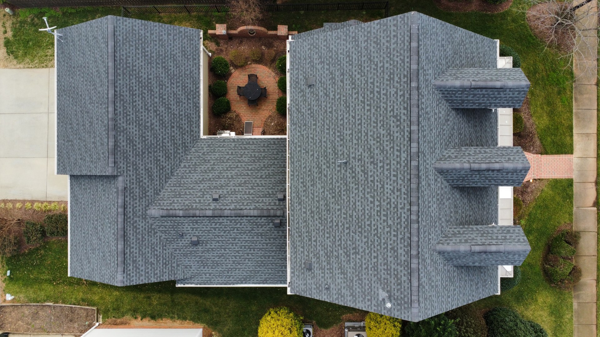 Top-down aerial view of a residential shingle roof published in Sunset Roofing and Construction's project gallery