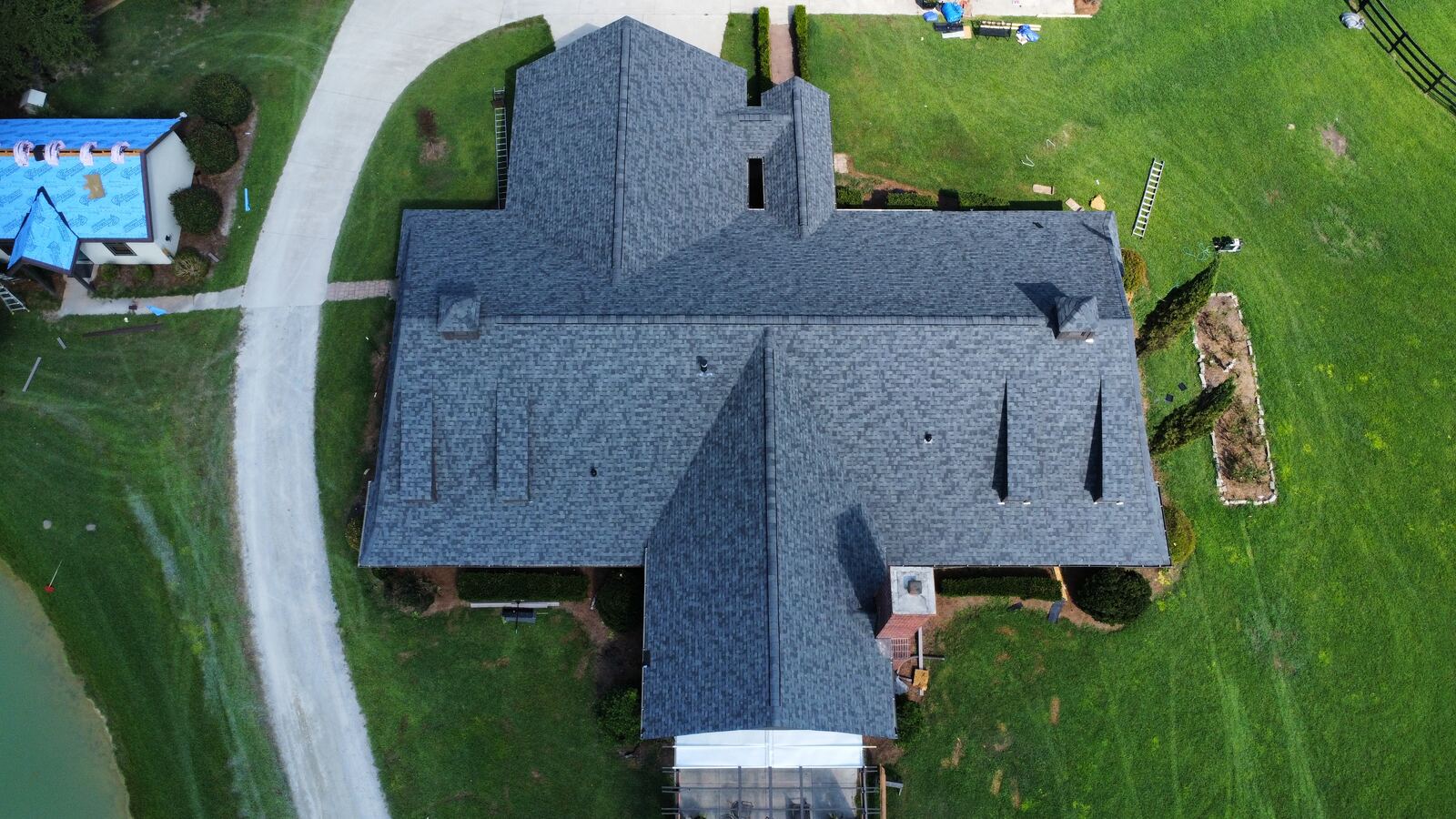 Aerial view of a home with a temporary tarp on the roof before restoration