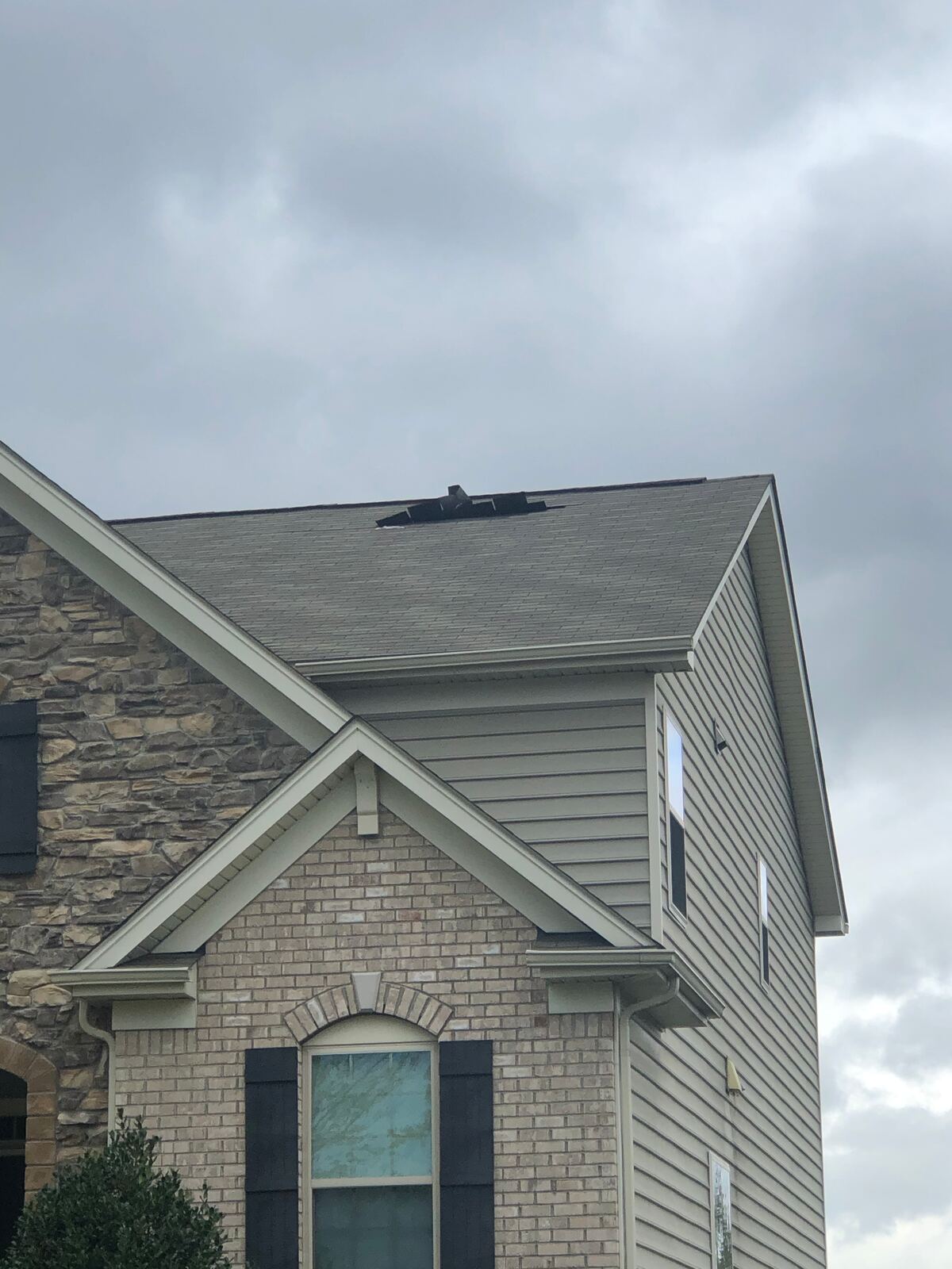Two-story home beneath dark storm clouds